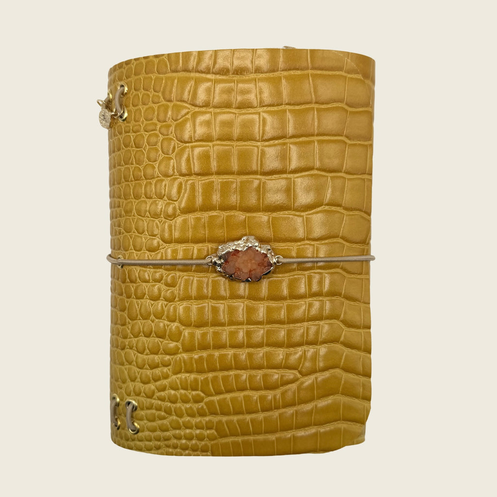 Mini Amber glow A6 Rich golden leather embossed with crocodile texture. Nature stone center piece, depth, light and quiet luxury.